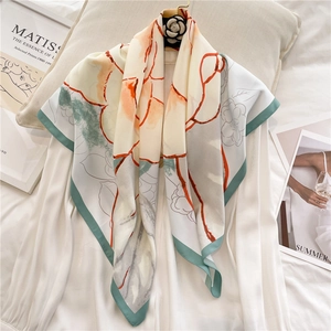Detail of camellia silk square scarf with abstract floral print and green border accents