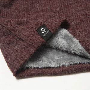 Close-up of winter neck warmer with dark red knit texture and gray fleece lining