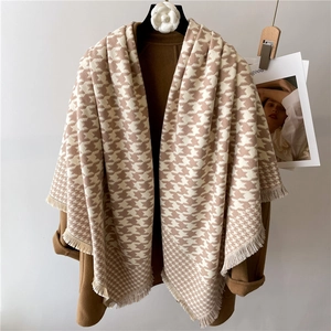 Brown houndstooth cashmere shawl with tassels over a wool coat for winter warmth
