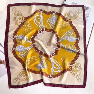 Detail of luxury silk square scarf featuring equestrian chain print and gold motifs