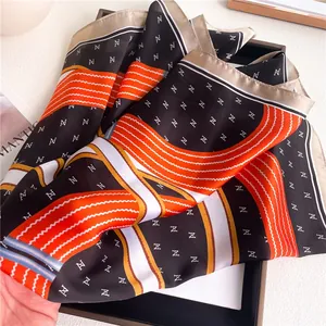 Macro shot of geometric print silk scarf with luxury pattern in orange and black