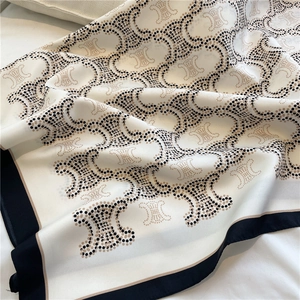 Close-up of silk square scarf showing textured drape and classic pattern details