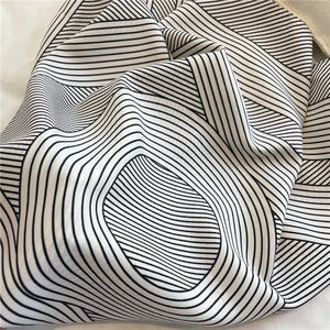 Close-up of high-quality fabric texture featuring black and white wave pattern print