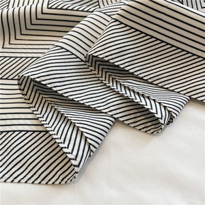 Close-up of black and white striped twill silk scarf showing fine texture and stitching