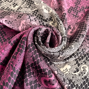 Detailed view of luxury lace pattern satin scarf with pink and black gradient texture