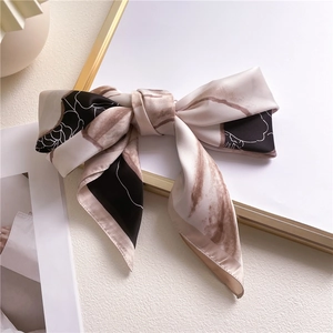 Elegant camellia silk square scarf with bow styling and sophisticated abstract line patterns