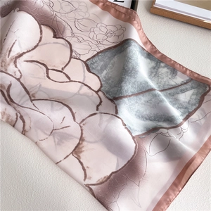 Detail of silk scarf showing camellia floral pattern and soft pastel color blocks