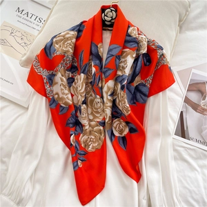 Detail of red floral silk scarf with gold camellias draped on a white silk shirt
