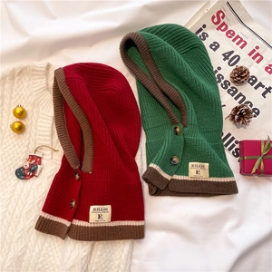 Detail of knitted hooded scarf set featuring contrast edges and elegant button closure