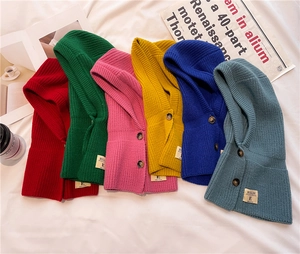 Flat lay of colorful knitted hooded balaclava scarves with button detail in six vibrant shades