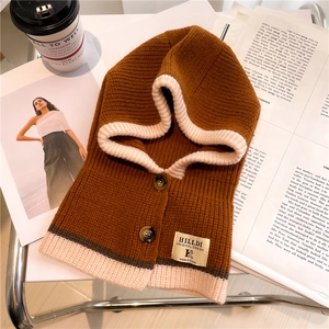 Detail of a brown knit hooded scarf with beige piping and branded woven label