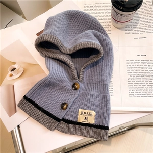 Detail of light blue knitted balaclava hood with contrasting grey trim and buttons
