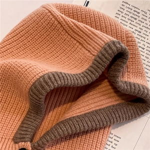 Close-up of thick salmon pink and gray knit balaclava showing detailed stitch texture