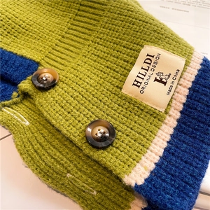 Detail of chunky knit fabric with contrast ribbing and tortoise shell buttons