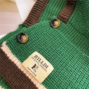 Detail of green knit cardigan with tortoiseshell buttons and branded fabric label