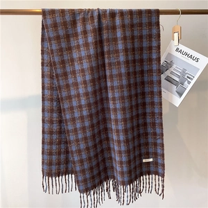 Detail of vintage plaid scarf with tassels in deep blue and brown thick faux cashmere