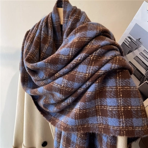 Detail of blue and brown plaid scarf on hanger with cozy cashmere wool texture