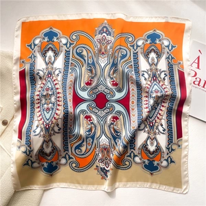 Elegant paisley square silk scarf in orange and blue, styled with a French magazine