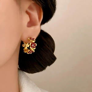 Elegant red enamel flower hoop earrings with gold plating and zircon center on model