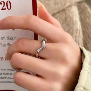 Anello ondulato in argento minimalista con finitura lucida indossato sul dito per stile