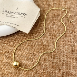 Collier minimaliste avec pendentif boule dorée, chaîne réglable et fermoir mousqueton