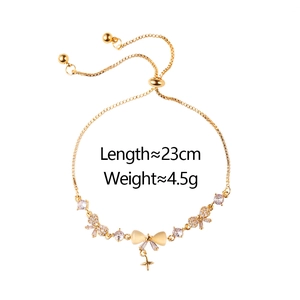 Close-up of gold bow bracelet with cat-eye stone, zircon accents and star charm