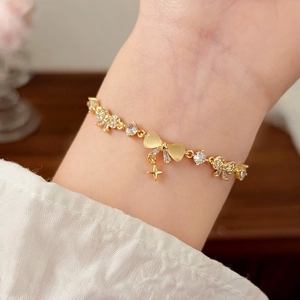 Elegant gold bow bracelet for women with opal cat eye stone and sparkling star pendant