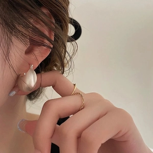 Minimalist matte champagne gold water-drop earrings and textured rings on a female model