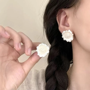 Elegant white floral stud earrings with textured petals shown on model for daily wear