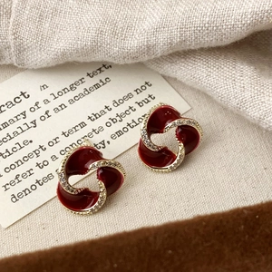 Detailed view of vintage dark red enamel spiral earrings with micro-inlaid zircons