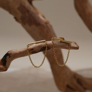 Minimalist gold chain drop earrings with polished bars hanging on a wooden branch