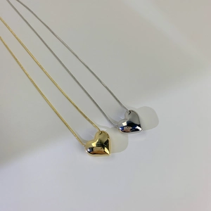 Vista dettagliata dei pendenti a cuore 3D in oro e argento su catene a serpente