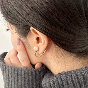 Elegant U-shaped gold plated geometric hoop earrings with pearl worn on ear