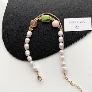 Detail of freshwater pearl bracelet with colorful stone charms and gold clasp