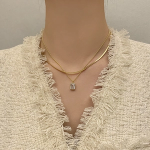 Double layered gold necklace set with rectangular zircon pendant and flat snake chain
