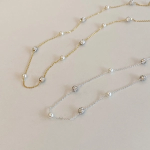 Détail de colliers perlés or et argent avec perles lustrées et sphères serties de strass