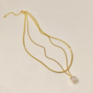 Detail of double-layer gold plated necklace with flat snake chain and rectangular stone