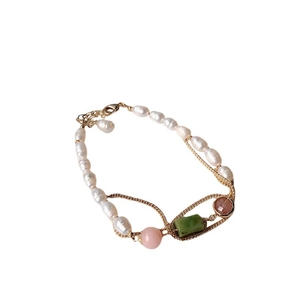 Elegant gold bracelet with freshwater pearls and assorted natural gemstones on white background