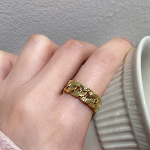Detail shot of a gold-plated Cuban link chain ring with fine textured surface details