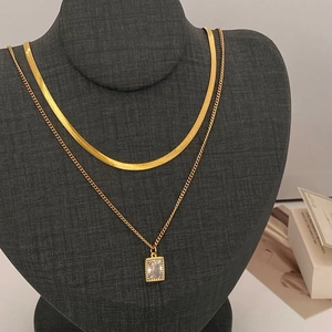 Double-layered gold necklace set with snake chain and rectangular clear gemstone pendant