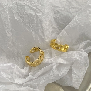 Detailed macro view of gold-plated chain rings with engraved Greek meander patterns