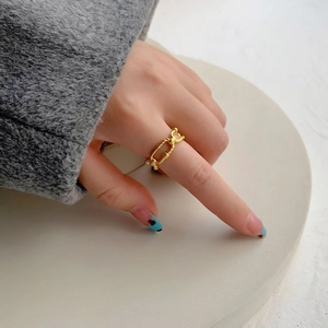 Detailed view of an irregular textured gold double-layer chain ring on a model hand