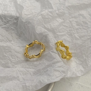 Macro shot of double layered gold wave rings showing fine spiral texture and polished finish