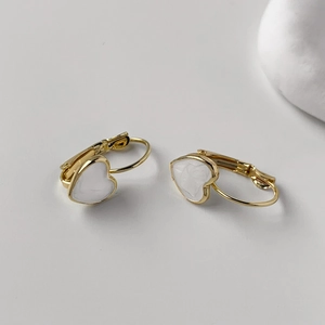 Detailed view of white heart leverback earrings with elegant gold-plated metal finish