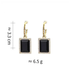 Détail montrant la longueur de 3,3 cm et le poids de 6,5 g des boucles d'oreilles zircon