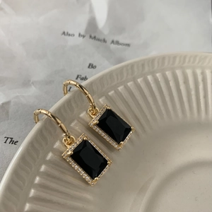 Detailansicht goldener Vintage-Ohrhänger mit schwarzem Kristall und Zirkonia-Besatz