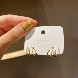 Close-up of gold-plated four-row earrings with micro-set cubic zirconia on a card
