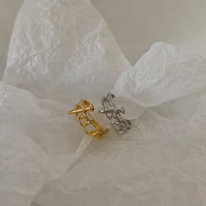 Close-up of gold and silver nail-shaped rings with hollow heart chain and cubic zirconia
