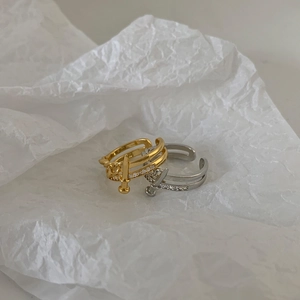 Macro shot of gold and silver hollow adjustable rings with zircon sword accents
