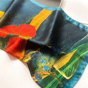 Detailed view of colorful ginkgo leaf patterns on premium silk-like peacock green scarf